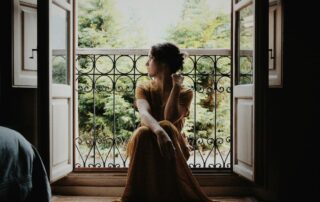woman-sitting-on-floor-near-window-at-daytime